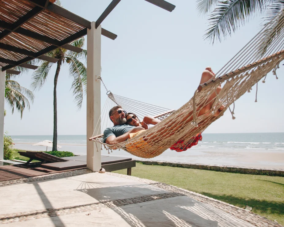 Two people are lying on a hammock